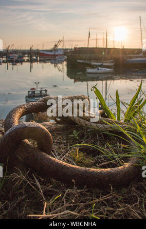 Chaîne d'amarrage rouillées au lever du soleil avec le port de Newlyn en arrière-plan, Portrait Banque D'Images