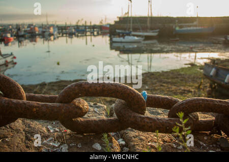 Bateaux dans le port de Newlyn avec chaîne de fer rouillé en premier plan Banque D'Images