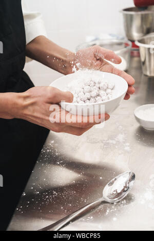 Photo recadrée d'un beau jeune cuisinier chef à la cuisine la cuisson à l'intérieur. Banque D'Images