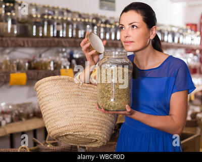 Femelle adulte américaine positive prendre une odeur d'herbes séchées naturel vendu au poids en eco shop Banque D'Images