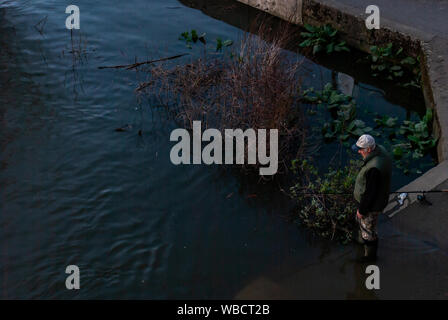 Londres, Royaume-Uni - Mai 14, 2019 : Oncle alors que la pêche sur les rives de la Tamise au coucher du soleil. Banque D'Images