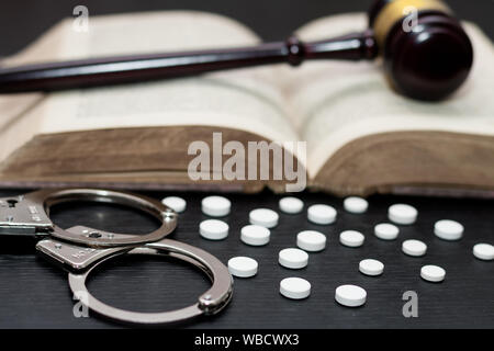 Marteau du Juge avec des menottes, les drogues on wooden table Banque D'Images