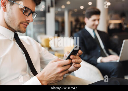 Image d'un concentré à l'intérieur d'affaires collègues dans le centre d'affaires office à l'aide de téléphone mobile et ordinateur portable. Banque D'Images