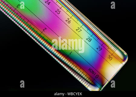 Image de polarisation croisée une règle indiquant les motifs colorés dans le plastique du stress Banque D'Images