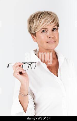 Portrait of attractive young woman holding eyeglasses and looking at camera isolated over white background en studio Banque D'Images