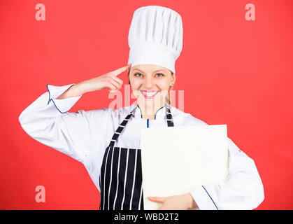 J'aime mon travail. menu du restaurant. Suivre un régime culinaire. chef professionnel en cuisine. Cuisine. Femme au chapeau et un tablier cook. happy woman la cuisson des aliments sains par recette. Femme au foyer avec livre de cuisine. Banque D'Images