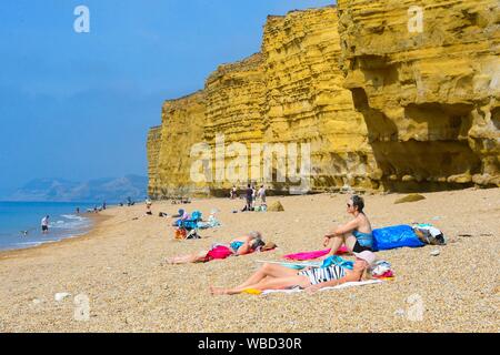 Burton Bradstock, Dorset, UK. 26 août 2019. Météo britannique. Les baigneurs et les vacanciers affluent à la plage à Burton Bradstock à Dorset pour un jour de températures chaudes et soleil voilé sur bank holiday lundi après un début de matinée brumeuse. Crédit photo : Graham Hunt/Alamy Live News Banque D'Images