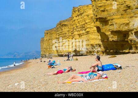 Burton Bradstock, Dorset, UK. 26 août 2019. Météo britannique. Les baigneurs et les vacanciers affluent à la plage à Burton Bradstock à Dorset pour un jour de températures chaudes et soleil voilé sur bank holiday lundi après un début de matinée brumeuse. Crédit photo : Graham Hunt/Alamy Live News Banque D'Images