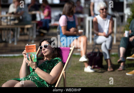 Sara Arhaim lire son livre 'Autumn' dans le soleil à Charlotte Square Gardens au 2019 Edinburgh International Book Festival, Édimbourg. Banque D'Images