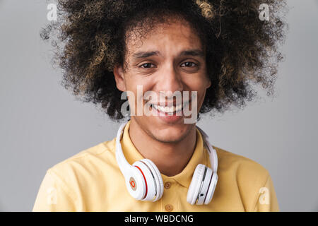 Photo de couple joyeux coiffure afro portant des écouteurs smiling at camera isolated over grey background Banque D'Images