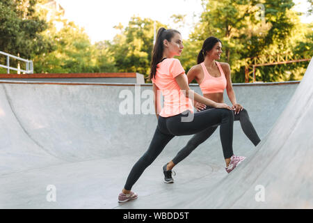 Image de femmes blanches dans les vêtements de sport athlétiques faisant des exercices concrets sur le terrain de sport Banque D'Images