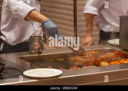 La cuisson des homards sur smoky chef cuisinière électrique dans la cuisine Banque D'Images