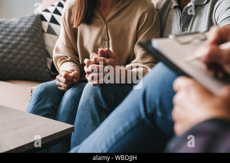 Photo recadrée de casual caucasian couple homme et femme d'avoir une conversation avec un psychologue sur séance de thérapie dans la chambre Banque D'Images