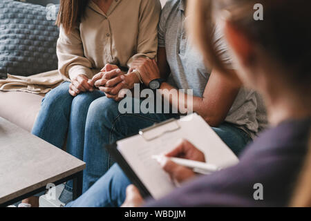 Photo recadrée de casual gentil couple homme et femme d'avoir une conversation avec un psychologue sur séance de thérapie dans la chambre Banque D'Images