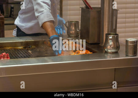 Asian chef cooking homard grillé sur cuisinière électrique dans la cuisine Banque D'Images