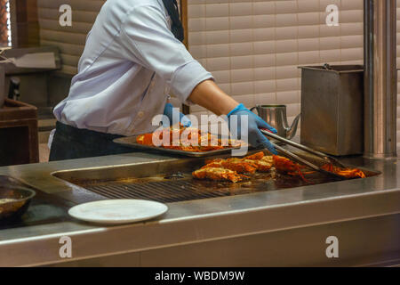 Restaurant chef cooking délicieux homards sur cuisinière électrique dans la cuisine Banque D'Images