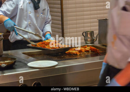 Le chef de la préparation du homard grillé à l'intérieur de la plaque de cuisine du restaurant Banque D'Images