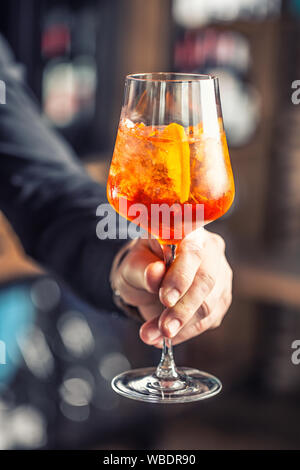 Aperol spritz boire. Barman hand holding glass avec Aperol Spritz verre Banque D'Images