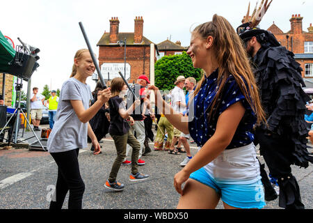 Folk Festival Ale et sandwich. Morris dance traditionnelle atelier en plein air avec des gens qui dansaient dans la rue.Deux jeunes adolescentes de la danse. Banque D'Images