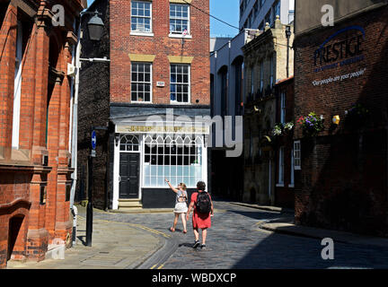 Deux jeunes femmes de visites sur la rue pavée, appelée le pays de gingembre vert, dans la vieille ville, Hull, East Yorkshire, England UK Banque D'Images