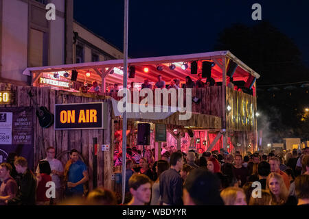 Stadtfest Brugg 24 août 2019. Éclairé rouge restaurant appelé Lasso par nuit avec des gens qui marchent à l'avant de l'auto, la construction. Banque D'Images