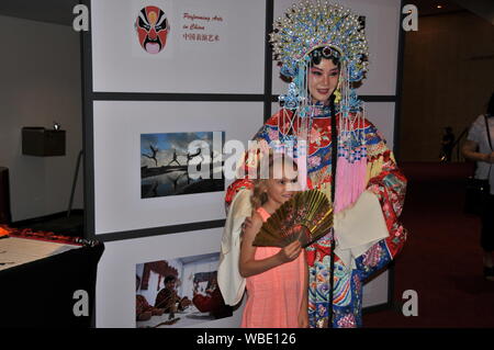 Houston, USA. Août 25, 2019. Une fille pose pour des photos avec une actrice au cours de l'Opéra de Pékin le Theatre District Open House à Houston, Texas, États-Unis, le 25 août, 2019. Consulat général chinois à Houston le dimanche à l'honneur la culture traditionnelle chinoise au Theatre District Open House. C'était la première fois que le consulat général a participé à l'événement annuel qui marque le début de l'automne Saison des arts à Houston. Credit : Liu Liwei/Xinhua/Alamy Live News Banque D'Images