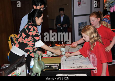 Houston, USA. Août 25, 2019. Une jeune fille tente d'utiliser la brosse pour écrire son nom chinois durant le Theatre District Open House à Houston, Texas, États-Unis, le 25 août, 2019. Consulat général chinois à Houston le dimanche à l'honneur la culture traditionnelle chinoise au Theatre District Open House. C'était la première fois que le consulat général a participé à l'événement annuel qui marque le début de l'automne Saison des arts à Houston. Credit : Liu Liwei/Xinhua/Alamy Live News Banque D'Images