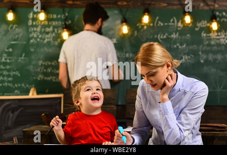 Désir d'aider doit être dans le tuteur par nature, jolie teacher helping élève en classe à l'école primaire, les élèves qui réussissent sont surtout Banque D'Images