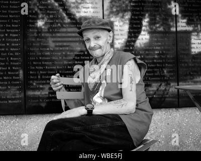 Frank Smith, un ancien combattant de la Seconde Guerre mondiale qui passe beaucoup de son temps dans les rues de Fort Worth, assise avec son chien en face de la Mur d'honneur de l'aviation en général Worth Square, au centre-ville de Fort Worth, Texas Banque D'Images