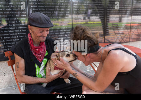 Frank Smith, un ancien combattant de la Seconde Guerre mondiale qui passe beaucoup de son temps, avec sa fille et à temps aidant, Julie Crawford, dans les rues de Fort Worth, siège avec Julie et son chien en face de la Mur d'honneur de l'aviation en général Worth Square, au centre-ville de Fort Worth, Texas Banque D'Images