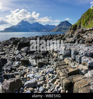 Black Cuillin Mountains sur l'île de Skye avec Loch Scavaig et la rive rocheuse de la baie de Glen Scaladal près d'Elgol au premier plan en juin, Écosse, Royaume-Uni Banque D'Images