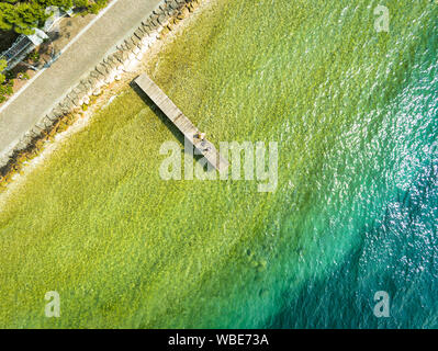 C'est une photographie aérienne d'un quai en bois sortir dans l'eau turquoise Banque D'Images