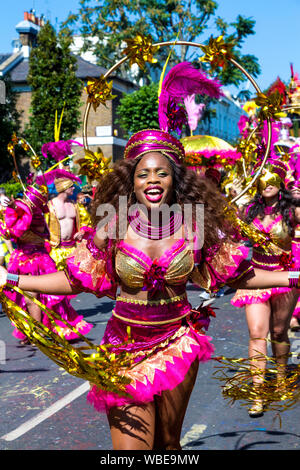 26 août 2019 - Femme habillé dans un costume rose et or avec chapeau et plume à Notting Hill Carnival sur une banque chaud lundi férié, Londres, Royaume-Uni Banque D'Images