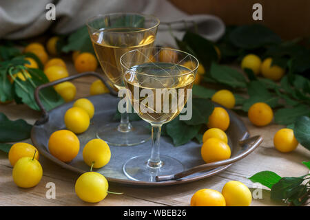 Cherry Plum dans de petits verres de liqueur de cerise et de prune sur un fond de bois. Style rustique. Banque D'Images