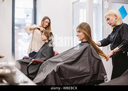 Belle femme le peignage des cheveux mouillés. Le brossage de cheveux femme styliste en coiffure. Coiffure au service client. Jeune professionnel Coiffure Travailler avec Comb Banque D'Images