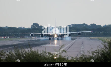 Un Airbus A380-861 Emirates Airlines émet de la fumée des pneus derrière lui-même car il touche le sol, avec la roue avant, toujours dans l'air. Espace copie ci-dessus. Banque D'Images