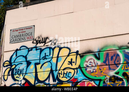 Graffiti sur un mur sur la route de la parade du carnaval de Notting Hill à Londres, signe de la rue Cambridge Gardens le Royal Borough de Kensington & Chelsea Banque D'Images