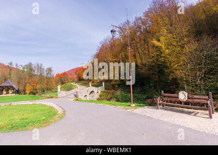 Beau parc dans les montagnes. merveilleux temps d'automne ensoleillé. arbres en automne feuillage. lanternes et des bancs le long du chemin, ciel bleu avec clo Banque D'Images