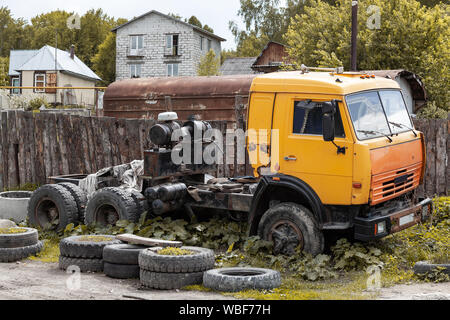 Un vieux gros camion jaune sans remorque lors d'une réparation ou de panne dans l'arrière-cour du village. L'équipement pour l'agriculture. Banque D'Images