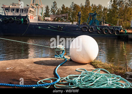 Une vieille bouée blanche se trouve sur le quai au port de pêche de la ville de, Finlande. C'est le début de l'automne et les bateaux de pêche ne sont pas sur la mer Banque D'Images