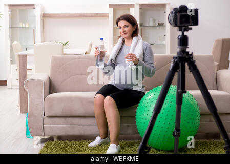 La femme enceinte blogger faisant des exercices physiques Banque D'Images