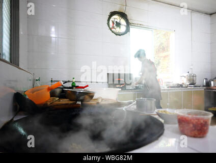 (190827) -- BEIJING, le 27 août 2019 (Xinhua) -- Liu Lihong cuit les aliments à la cuisine du gouvernement local dans Dabaidi Canton de Ruijin City, province de Jiangxi, Chine orientale, le 7 mai 2019. Le port d'un béret noir et une paire de chaussures à haut talon, Liu Lihong sautés de légumes viande et légumes à l'aide de fourneaux de cuisine tout en écoutant de la musique, une scène typique dans sa routine quotidienne. Le 40-year-old chef a travaillé pour le gouvernement local du Dabaidi Township sur trois ans. Avant d'être un cuisinier professionnel, Liu est un travailleur migrant dans une usine de confection à Shantou du sud de la province chinoise du Guangdong tr Banque D'Images