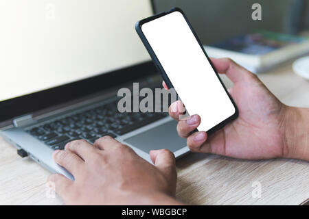 Business man hand holding smart mobile phone, en utilisant une carte de crédit pour faire des achats en ligne avec un ordinateur portable et tablette numérique sur table. Concept Cyber Banque D'Images