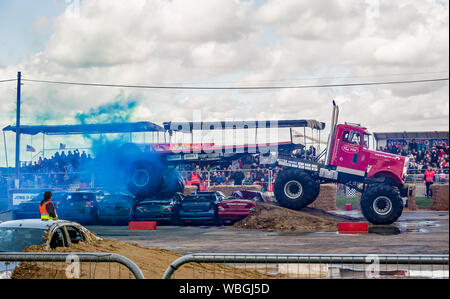 Le monster truck Big Pete écraser une pile de voiture, en tractant une remorque sur mesure sur mesure au cours d'une manifestation à un monster truck show Banque D'Images