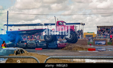Le monster truck Big Pete écraser une pile de voiture, en tractant une remorque sur mesure sur mesure au cours d'une manifestation à un monster truck show Banque D'Images