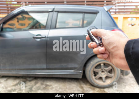 L'ouverture d'affaires porte sa voiture avec le bouton sur la télécommande de contrôle. Banque D'Images