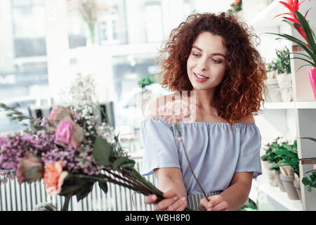 Appel dame rousse étant occupé avec la composition de bouquets Banque D'Images