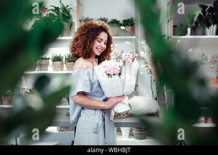 Cheerful short-haired young lady d'être heureux avec le thème du printemps bouquet Banque D'Images