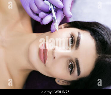 Injections de beauté close up. Une belle brunette d'âge moyen obtient les injections de beauté, thérapie anti rides, rajeunissement de la peau Banque D'Images