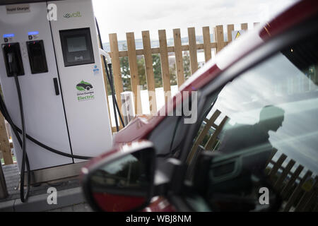 Ryan Todd, propriétaire de sept voitures à moteur électrique fonctionne comme un taxi dans son entreprise de taxis de Todd, frais sa voiture à la station de charge électrique de Princes Street, l'une des trois stations de ce genre dans la ville, à Dundee, en Écosse, le 14 août 2019. Banque D'Images